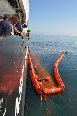 A Coast Guard crew skims oil on the Gulf. CC license: Wikimedia commons