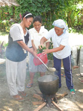 Bibing (left) and other women making one of the natural "concoctions" that have replaced chemical fertilizers and pesticides in organic agriculture. All the ingredientscan be grown at the farm or purchased at the local market. Photo by Robin Broad.
