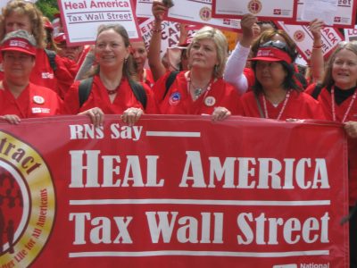 Nurses display a banner calling for a tax on Wall Street. Photo by Sarah Anderson