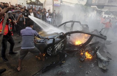 Palestinians help extinguish the fire after an Israeli air strike on the car of Hamass top commander, Ahmed Al-Jaabari, in Gaza City, November 14, 2012. Reuters/Stringer