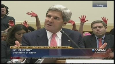 Code Pink holds up bloody hands behind Secretary of State John Kerry throughout two-hour hearing.