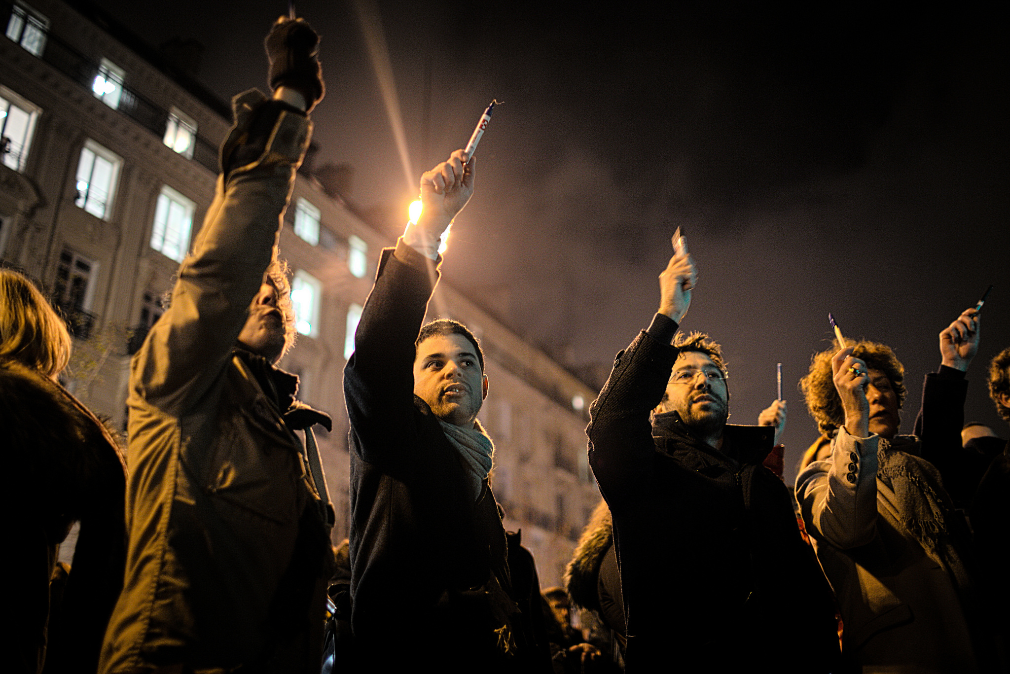 Charlie Hebdo protestors raise pens in solidarity.