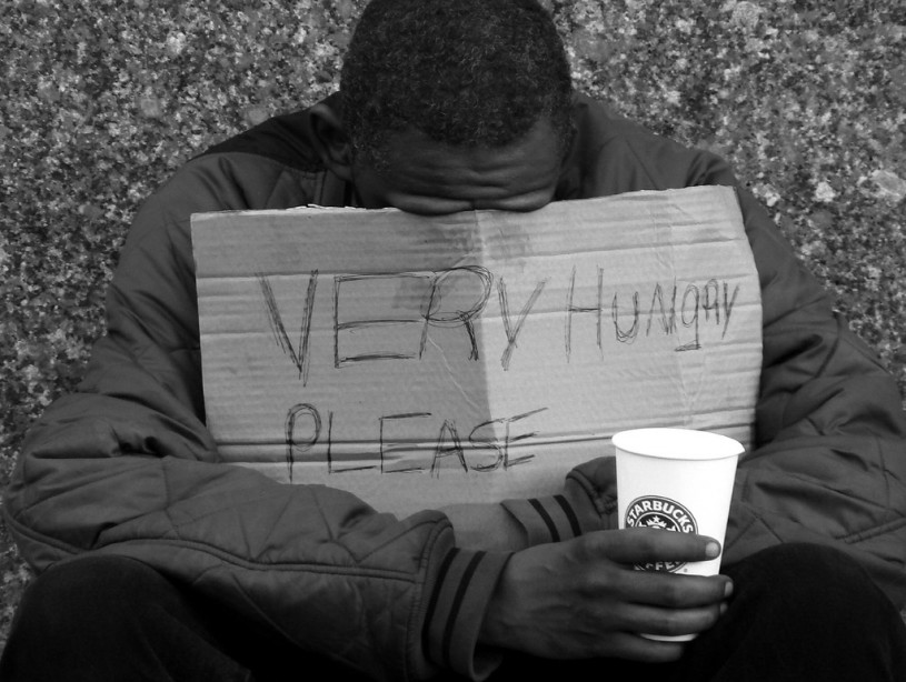 Homeless man holding sign 'Very Hungry Please'