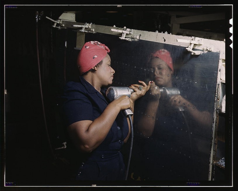 black worker holds hand drill