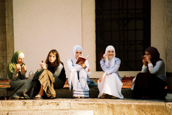 women-hijab-reading-eating-sidewalk