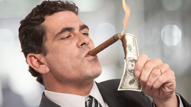 Rich CEO lighting cigar with money