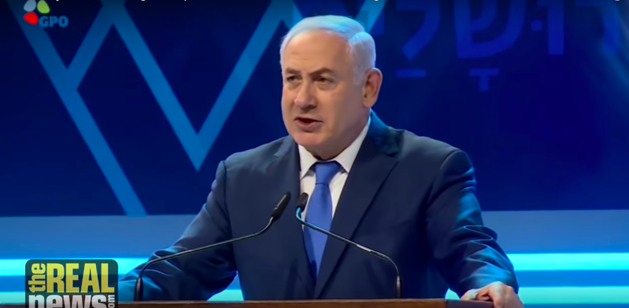 Benjamin Netanyahu speaking at a podium.