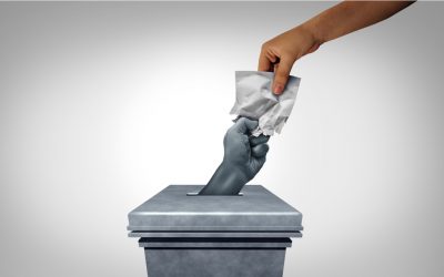 democracy - vote cast by dropping a ballot into a ballotbox