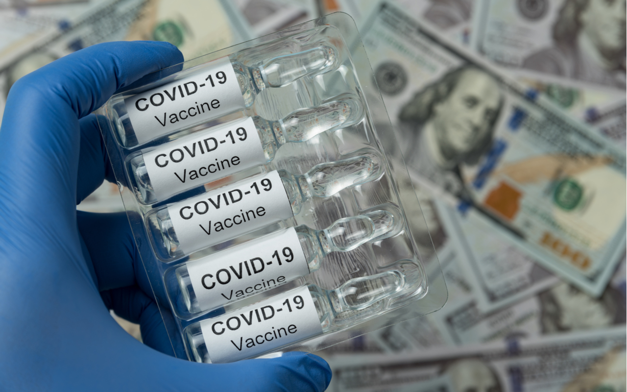 Packaging of ampoules with the vaccine COVID-19 in hand. Close-up. Money on the background