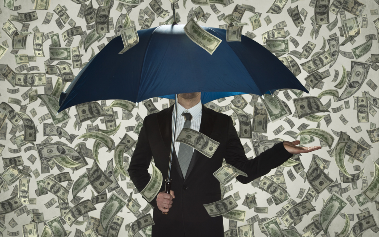 money rain over man with umbrella to decipt billionaire wealth gains amid the covid-19 pandemic at one year anniversary of pandemic