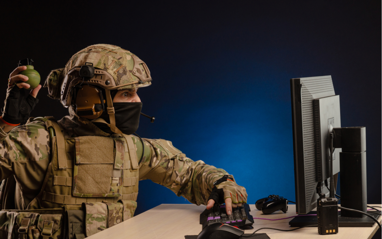military in uniform sitting at a computer are cyberwar, playing, throwing a grenade