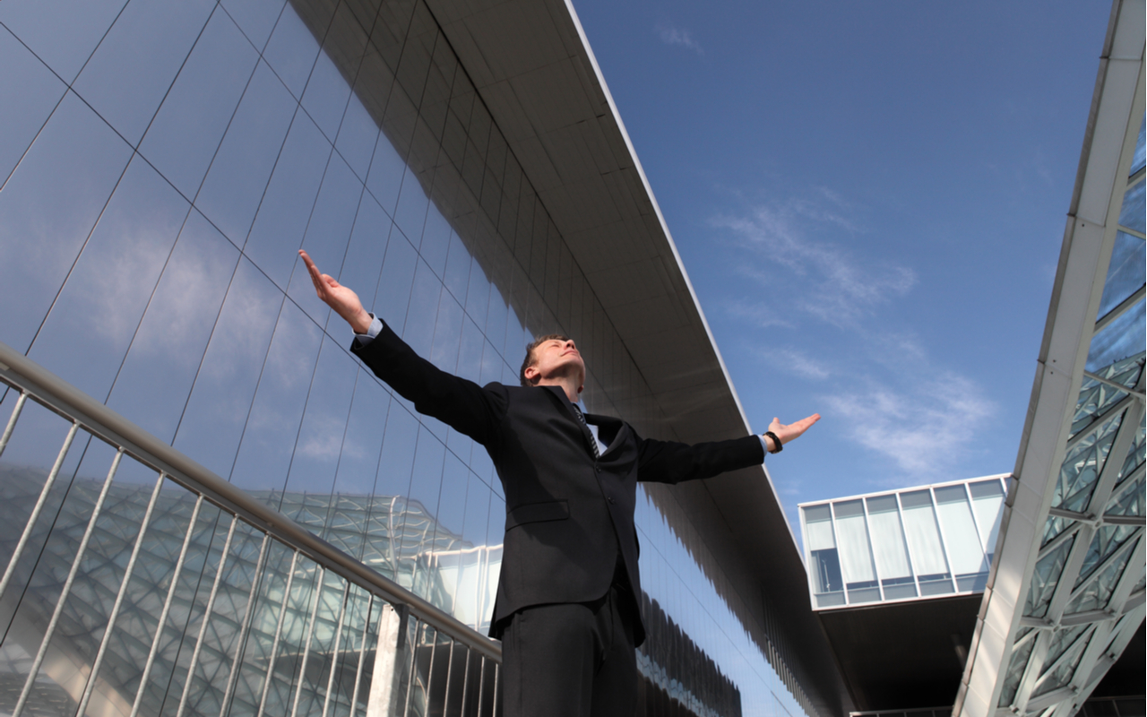 businessperson happily looking toward the sky