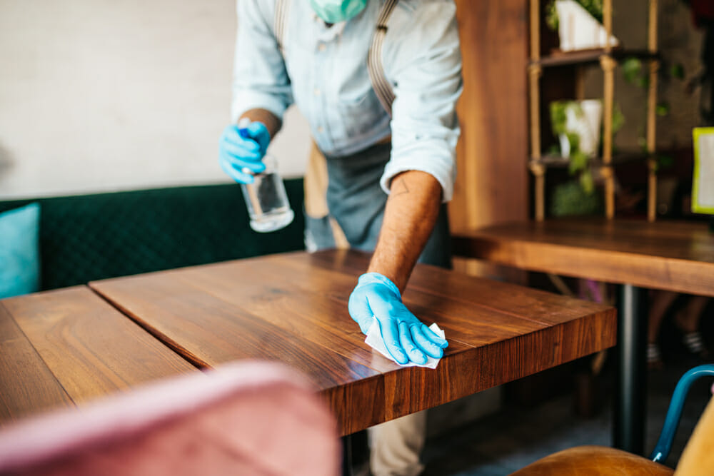 restaurant worker cleaning a table