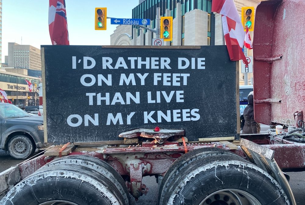 sign at canadian trucker freedom convoy reads i'd rather die on my feet than live on my knees