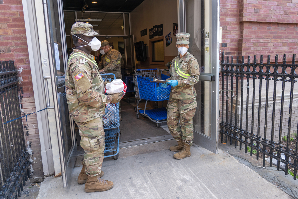 Members of the National Guard help distribute food during the pandemic. Many communities have had to rely on the Guard because they lack funding for other priorities.
