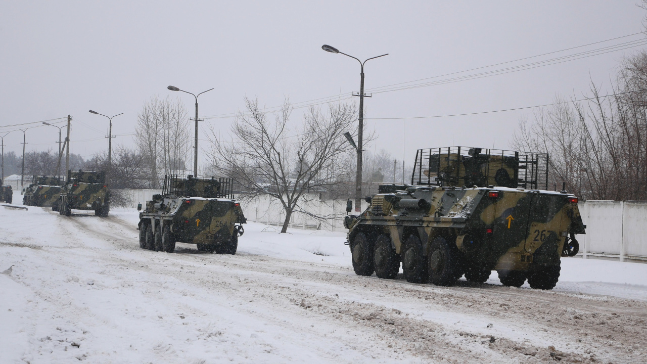 A column of armored personnel carriers rides on a winter road. Ukraine prepares to defend its country from Russian invasion