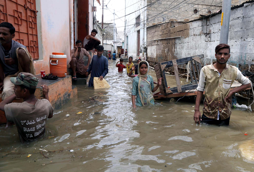 Residents in a flooded quarter of Karachi, Pakistan, August 2022 (Shutterstock)