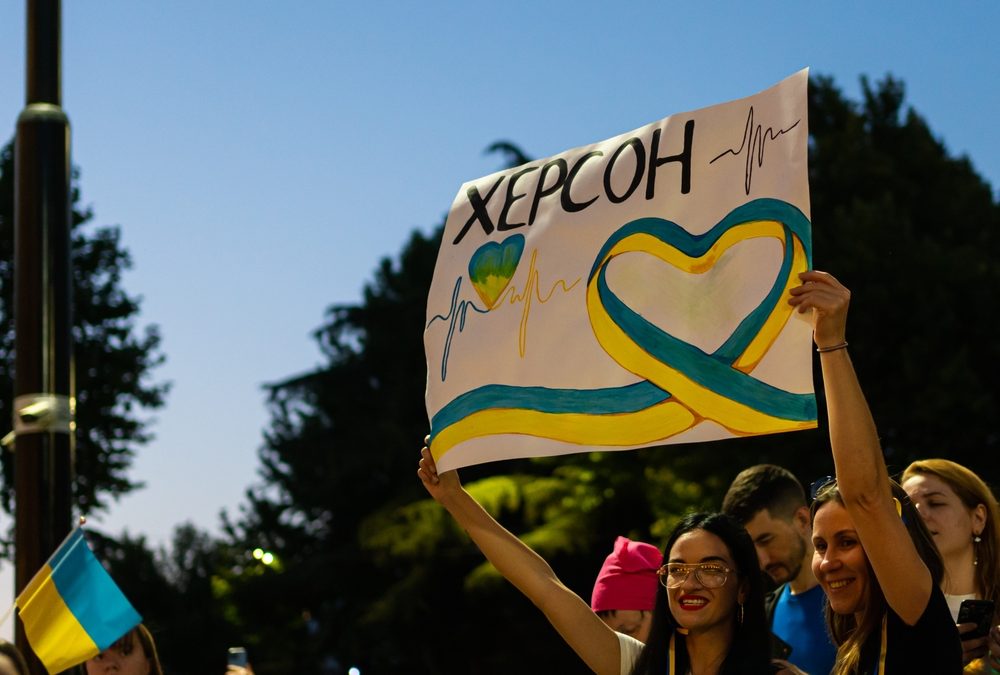 Protestor at a rally in Tbilisi holding at a sign that reads "xepcoh."