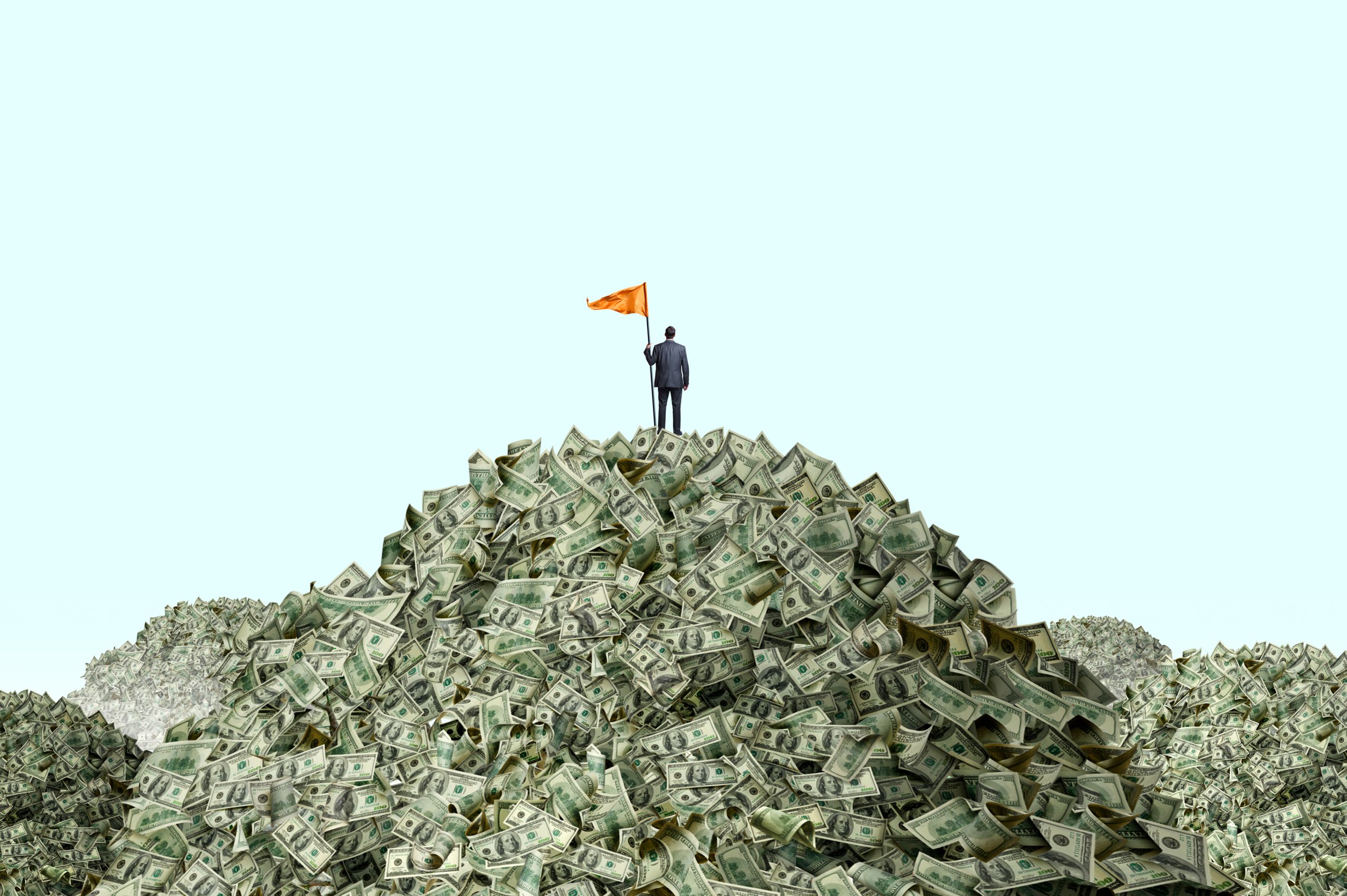 Image shows huge mounds of money, one of which has a man in a suit on top of it planting a flag.