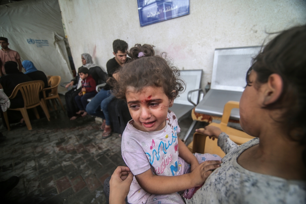 Wounded Gazan families prepare to flee a refugee camp Israeli forces bombed in Rafah, Gaza, October 2023 (Shutterstock)